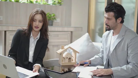 Couple talking and working with laptop computer together in office.  business Stock Footage 168667694