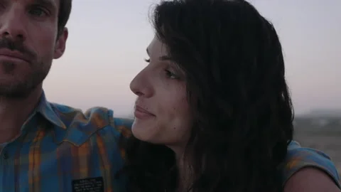 Couple talking on the beach while looking st sunset Stock Footage 131159161