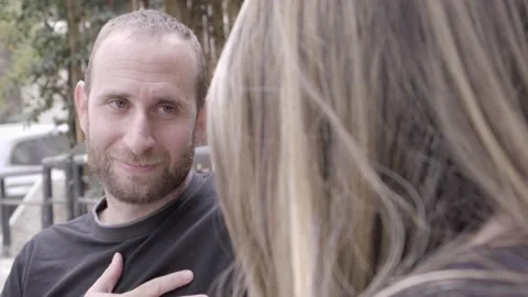 Couple talking on a bench having a dialogue. Man chatting with a woman Video stock 157359116
