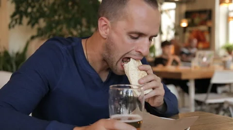 Couple talking, eating and drinking beer in cafe in the city Stock Footage 67862594