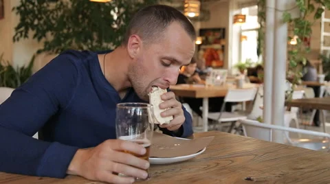 Couple talking, eating and drinking beer in cafe in the city Stock Footage 67862639