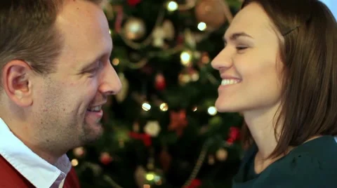 Couple talking in front of christmas tree, close up Stock Footage 10741873