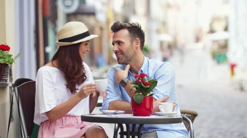 Couple talking at outdoors cafe sitting by table on street Stock Footage 52783053