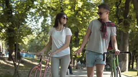 Couple Talking as Walking with Bikes Stockbeeldmateriaal 91794324