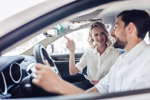 Couple talking while driving a car Stock Photos