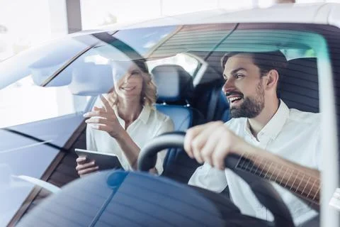 Couple talking while driving a car Stock Photos