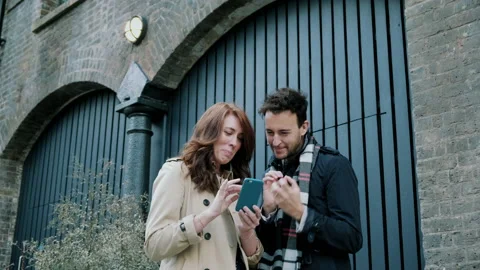 Couple talking while looking at phone Stock Footage 130598516
