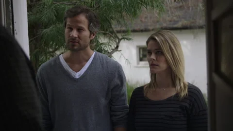 Couple talking while standing at door of their new neighbors house Stock Footage 202907276