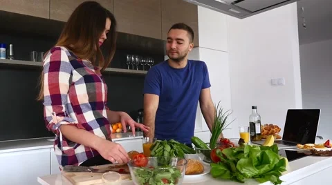 Couple is tasting and preparing some food in the kitchen. Stock Footage 61859430