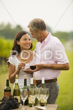 Couple tasting wine together outdoors Stock Photos