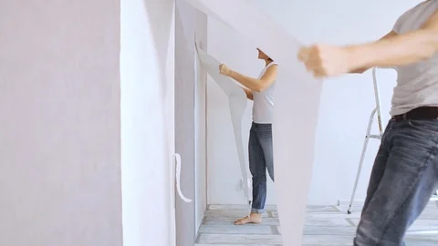 Couple tear down wallpapers in room where they starting reconstruction Stock-Footage 100726479