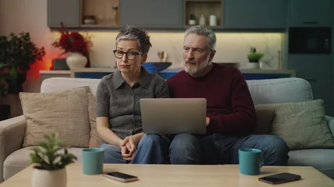 Couple in their 50s reading bad news email on laptop, rejected visa application Stock Footage 340919721