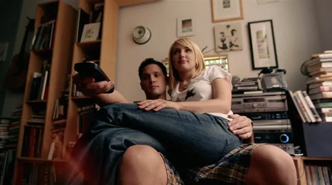 Couple in their apartment using a remote to watch television Stock Footage 46157857