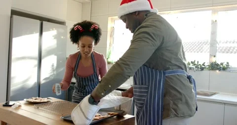 Couple tilting cookie tray, transferring onto wire rack, sampling leftover dough Stock Footage 340009954