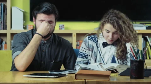 Couple of tired students sitting in the class room slow motion Stock Footage 59185847