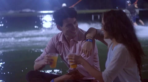 Couple toasts, drinks at wakeboard lake Stock Footage 63080938