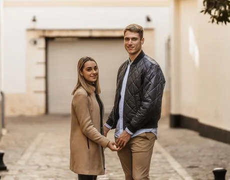 A couple touching hands while looking smiling at the camera Stock Photos