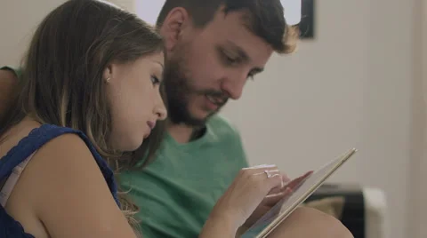 Couple touching the tablet to watch shows and movies on the Internet Video stock 59325924