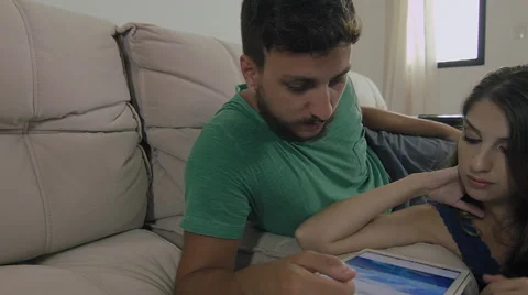Couple touching the tablet to watch shows and movies on the Internet Video stock 59326946