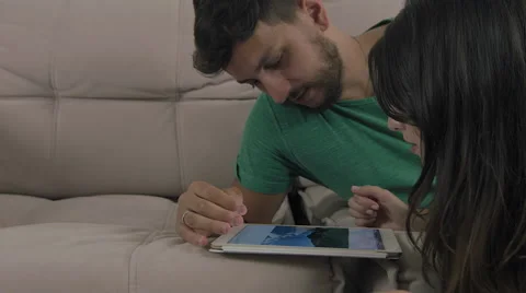 Couple touching the tablet to watch shows and movies on the Internet Video stock 59327046