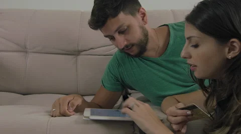 Couple touching the tablet to watch shows and movies on the Internet Video stock 59327712