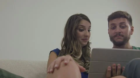 Couple touching the tablet to watch shows and movies on the Internet Video stock 59330176
