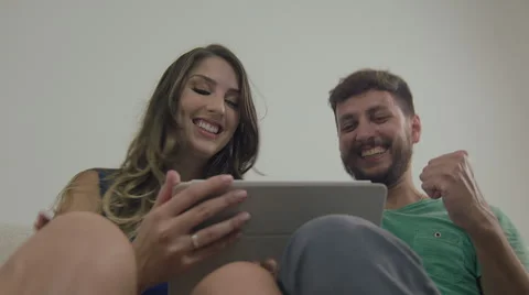 Couple touching the tablet to watch shows and movies on the Internet Video stock 59330649