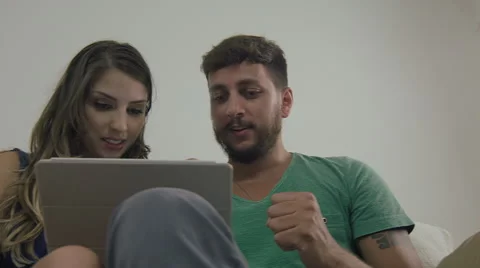 Couple touching the tablet to watch shows and movies on the Internet Video stock 59330683