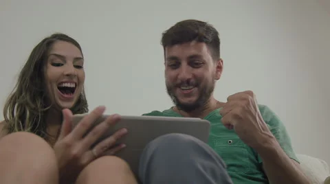 Couple touching the tablet to watch shows and movies on the Internet Video stock 59330764