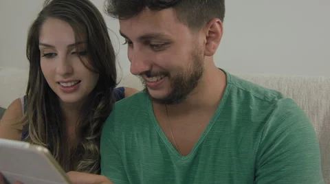 Couple touching the tablet to watch shows and movies on the Internet Video stock 59331794
