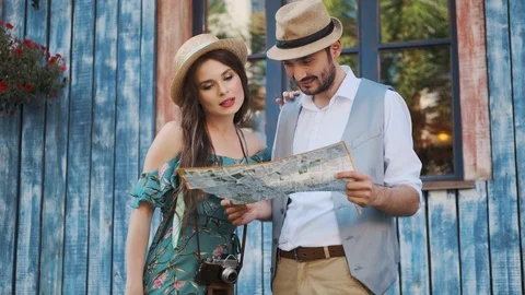 Couple of tourists are exploring the map in travel. a young woman and a man walk Stock Footage 113638988