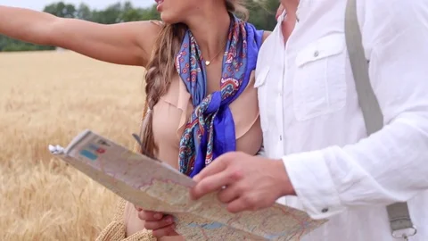 Couple of tourists looking at the map against the background of wheat Stock Footage 77798251