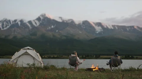 A couple of tourists sit by the fire in the evening. Stock Footage 280726016