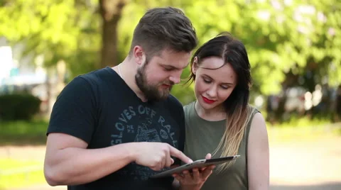 Couple in town connected on digital tablet Stock Footage 50981406