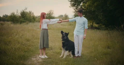 Couple Training German Shepherd at Sunset Stock Footage 318931842