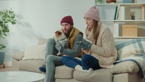 A Couple Try to Warm Up Their Dog in the Cold Room Without Central Heating. Stock Footage 222439905