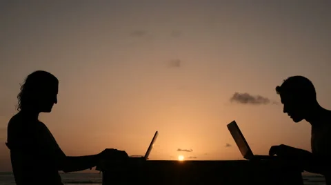 Couple typing on laptop during sunset Stock Footage 61139512