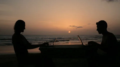 Couple typing on laptops during sunset Stock Footage 61139391