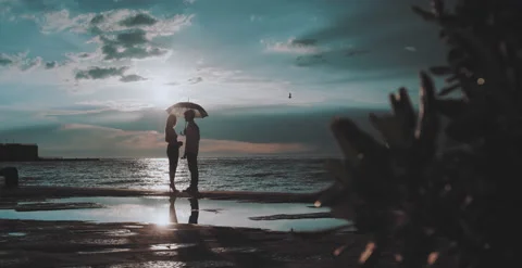 Couple with umbrella stand on beach Stock Footage 204973292