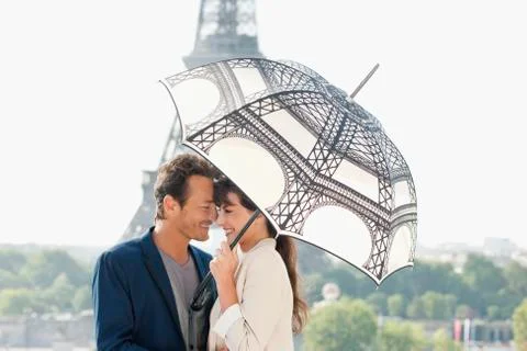 Couple under an umbrella with the Eiffel Tower in the background, Paris, Fotos Stock