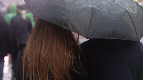 Couple under an umbrella walking down the street where. Young people walking 스톡 동영상 131893099