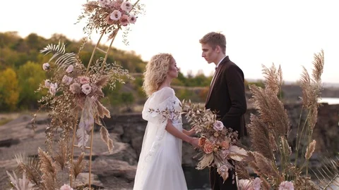 Couple under wedding arch look on each other Stock Footage 122424969
