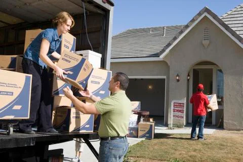 Couple Unloading Moving Boxes Into New House Stock Photos
