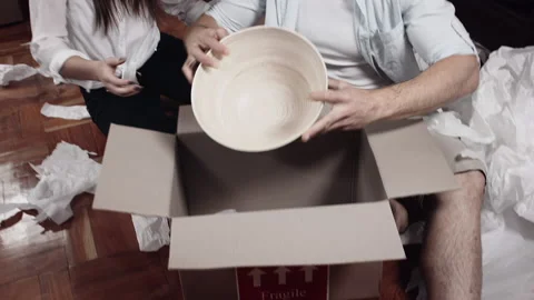 Couple unpacking boxes and organizing/ arranging  placement for their stuff for Stock-Footage 199631641