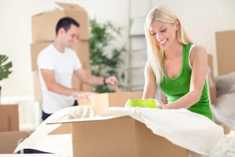 Couple unpacking boxes Stock Photos