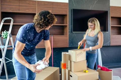 Couple unpacking moving boxes Stock Photos