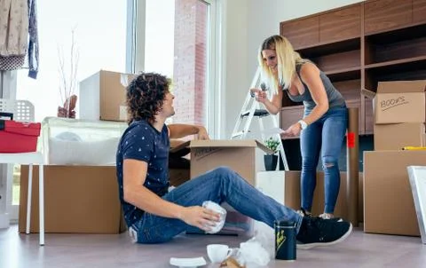 Couple unpacking moving boxes Stock Photos