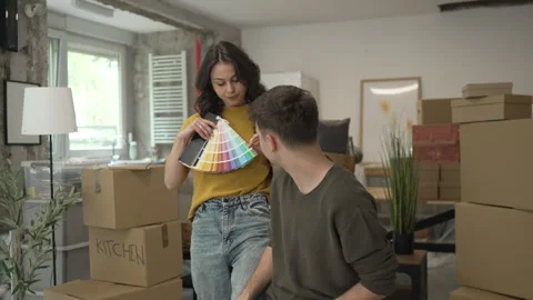Couple use tablet and color palette to choose color for paint wall Stock Footage 320645341