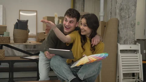Couple use tablet and color palette to choose color for paint wall Stock Footage 320645345