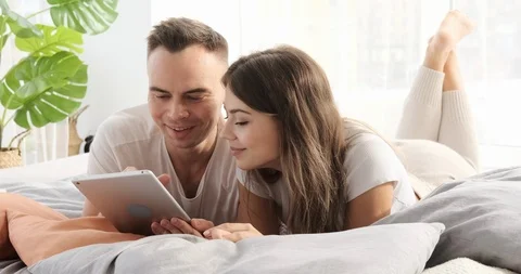 Couple using digital tablet in bed Stock Footage 120928871